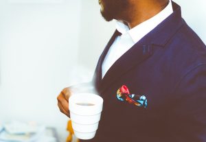 man in a suit drinking coffee