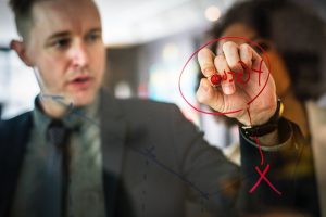 Man Writing on a Glass Board: Effective Operations Manager Job Description for Applicants