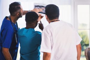 Three men looking at a picture and needs a medical resume