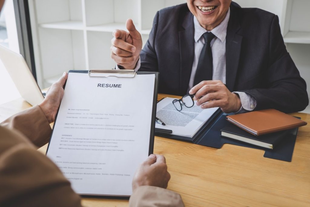 selection committee manager browsing resume keywords during job interview