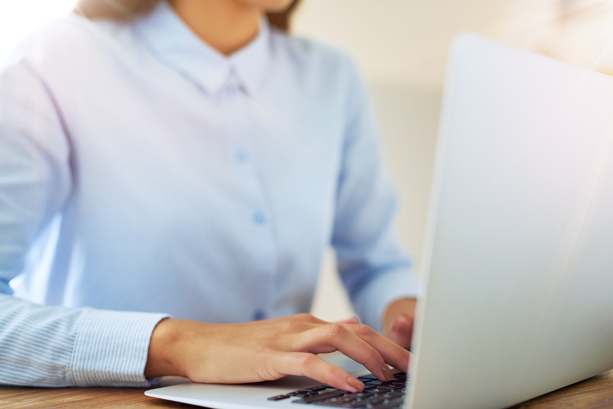 Young woman typing ATS resume on a laptop computer