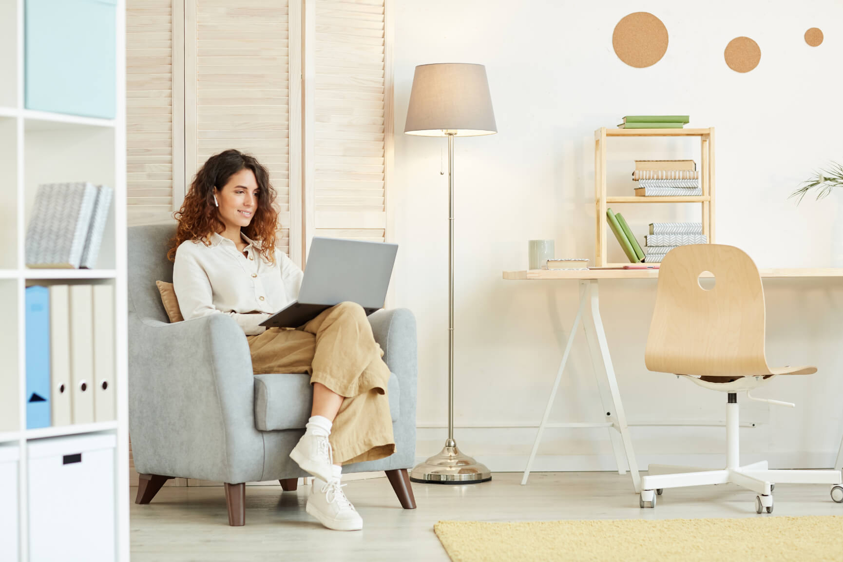 Woman sitting on a couch while using her laptop in her working space