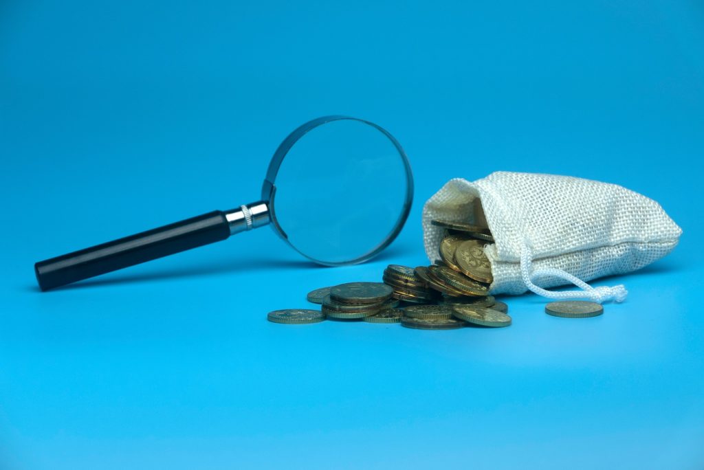 how long does it take for a background check: photo of magnifying glass and gold coins