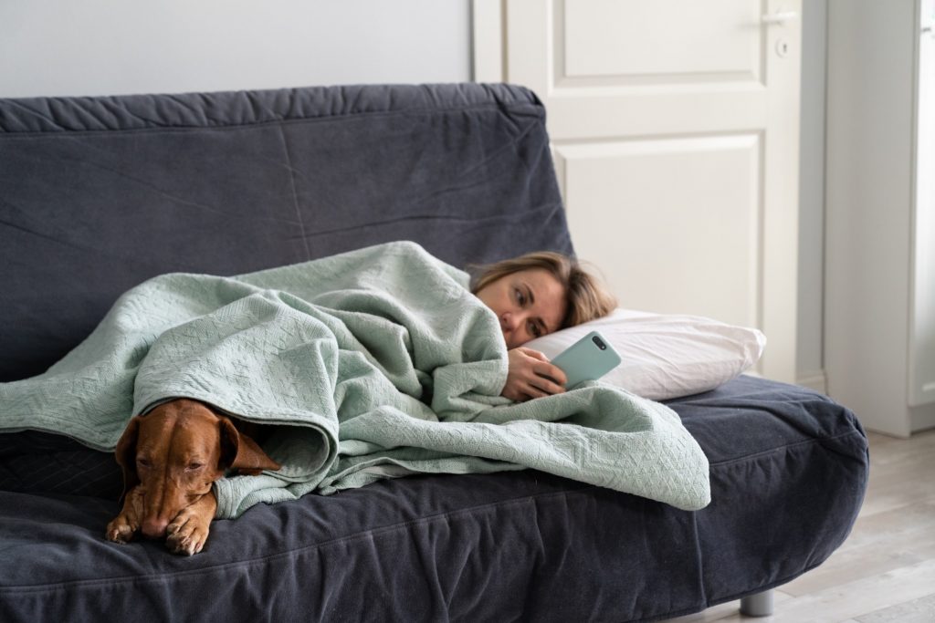 woman on couch waiting to hear back after an interview