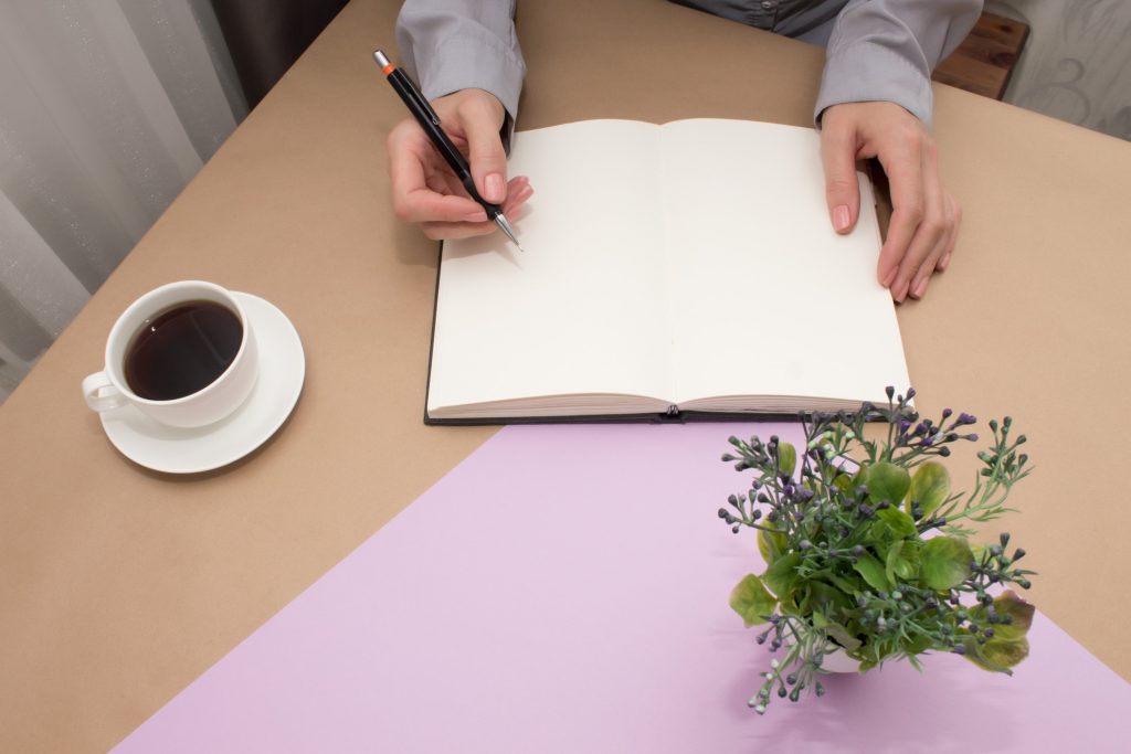 woman writing her career development goals on a journal