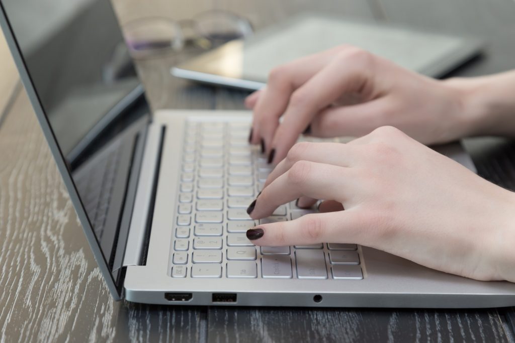 girl typing on her laptop