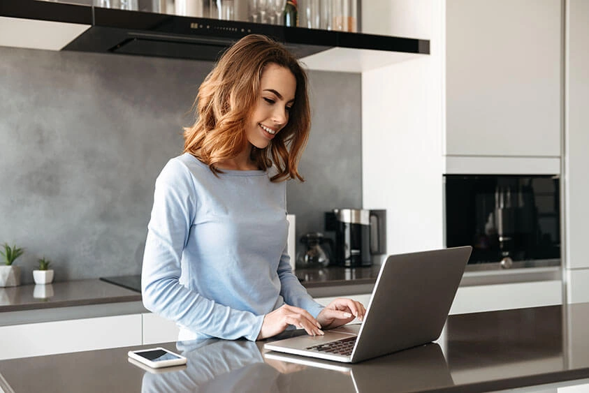woman using laptop in the kitchen